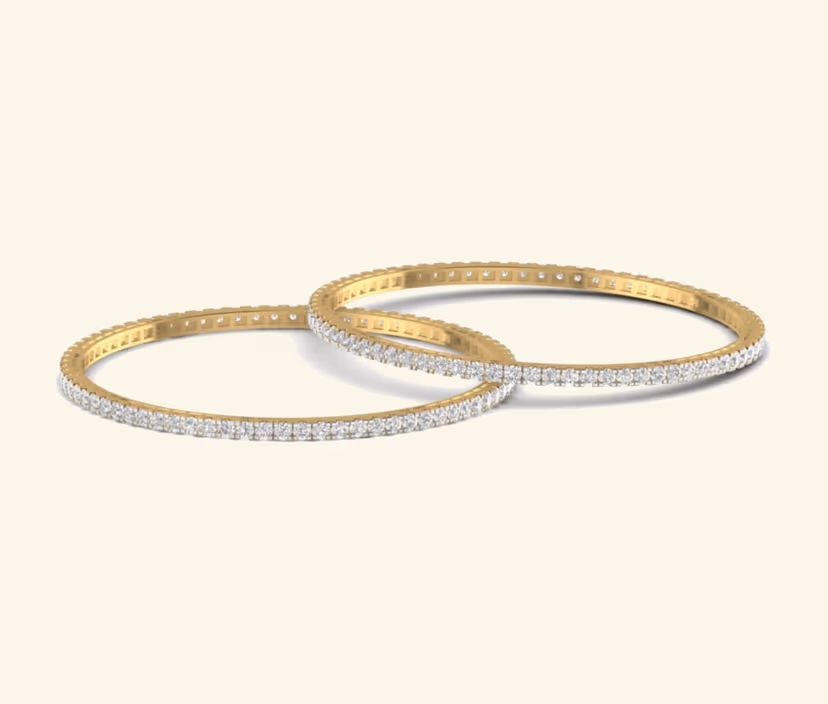Diamond tennis bangle pair with continuous two-tone setting.