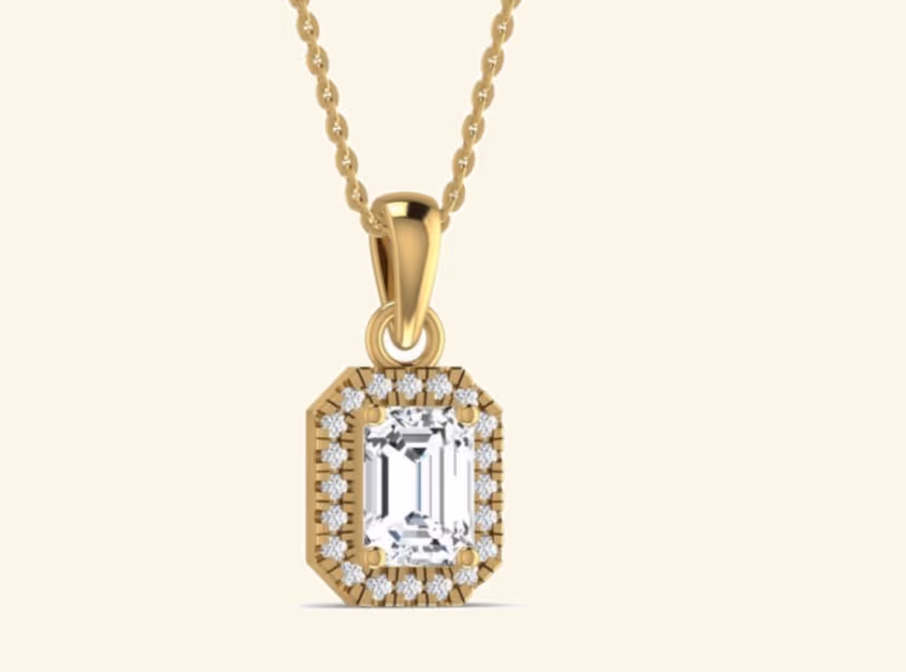 Emerald-cut solitaire pendant with pavé halo on cable chain.