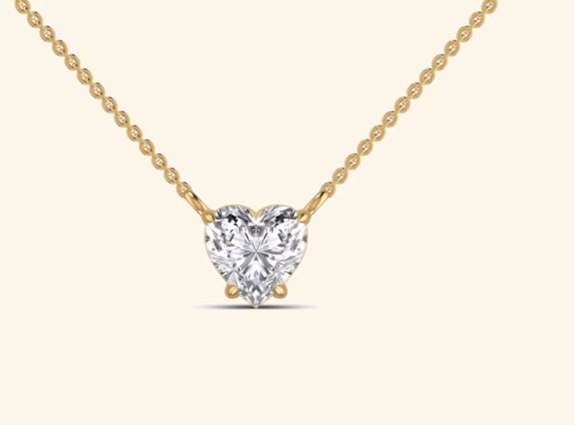 Heart-cut diamond solitaire pendant with three-prong setting on cable chain.