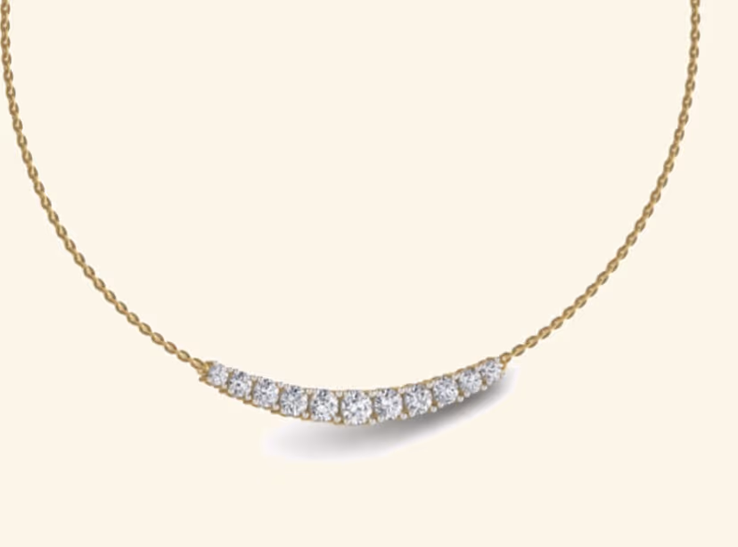 Curved nine-stone graduated tennis bar smile pendant.