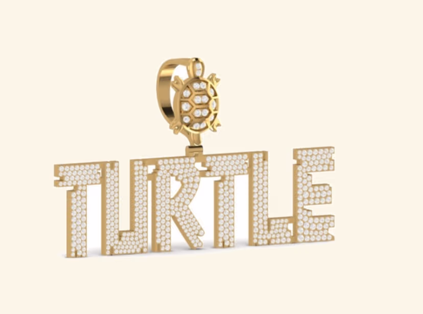 TURTLE iced block-letter pendant with turtle motif on pavé bail.