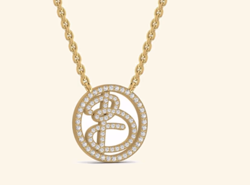 Round openwork pendant with cursive B letter and pavé halo borders.